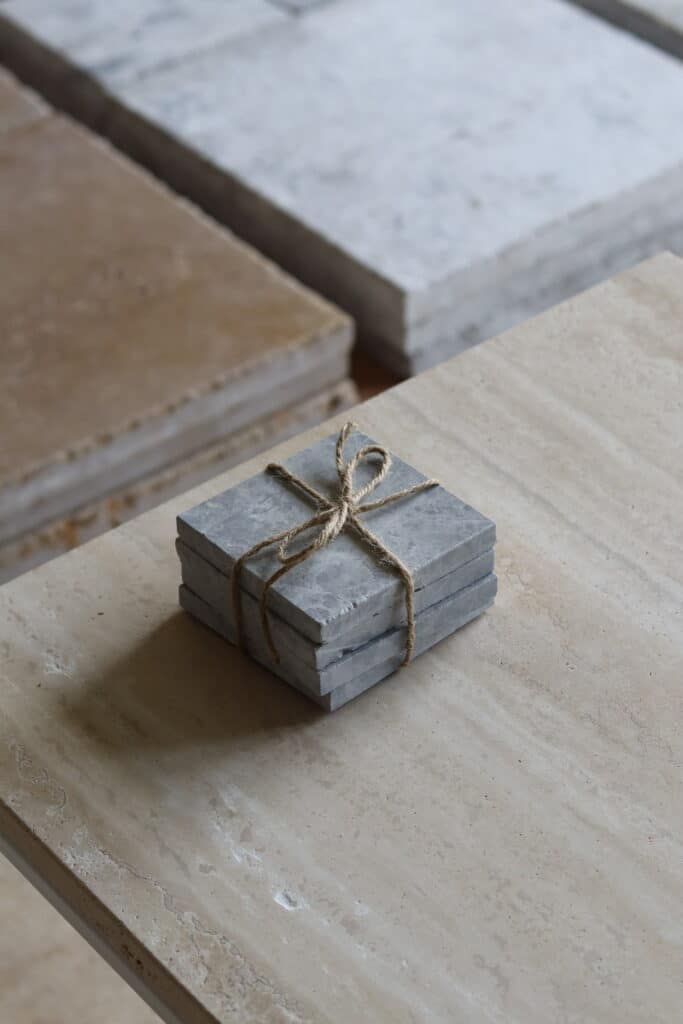Próbki marmur Thundra Grey Szlifowany o wymiarach 10x10 cm, ułożone jedna na drugiej i związane sznurkiem.