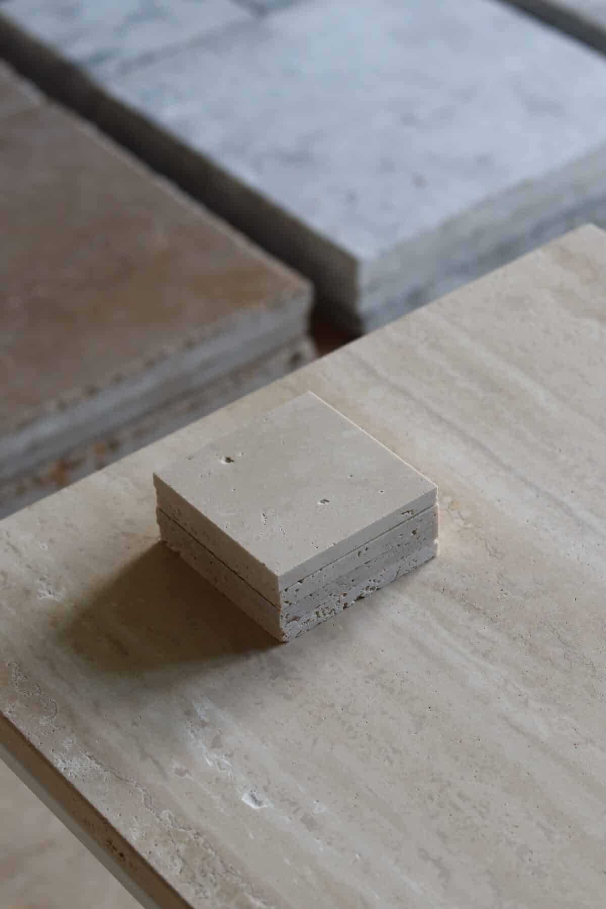 Próbki trawertyn szachownica Super Light & Silver Premium Szlifowany o wymiarach 10x10 cm, ułożone jedna na drugiej, bez sznurka.