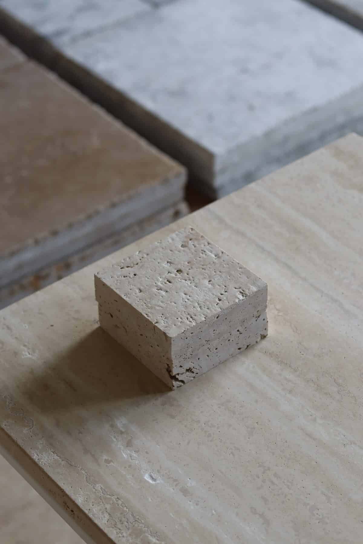 Próbki trawertyn Classic Light 3cm Szczotkowany o wymiarach 10x10 cm, ułożone jedna na drugiej, bez sznurka.
