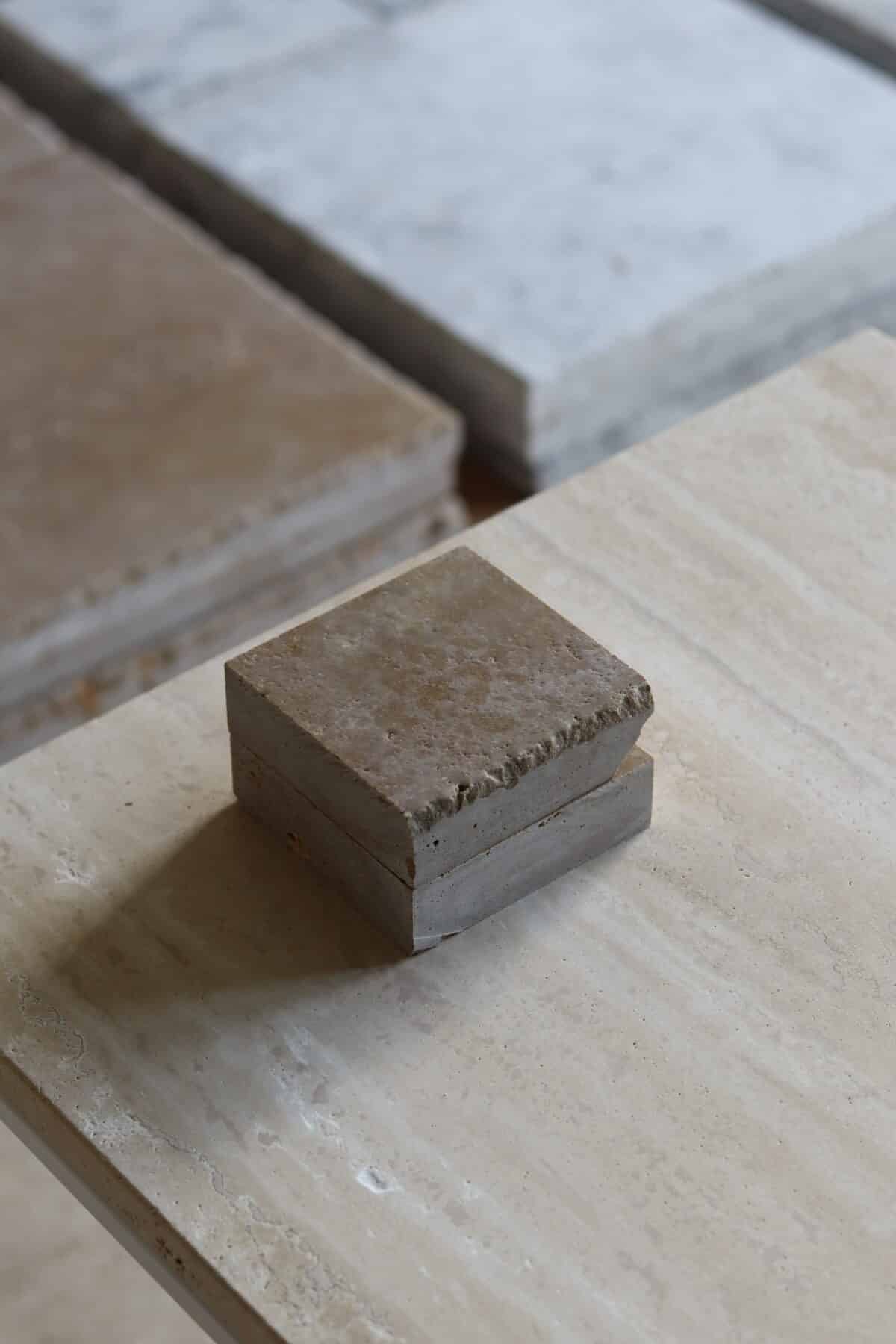 Próbki trawertyn Noce 3cm Szczotkowany o wymiarach 10x10 cm, ułożone jedna na drugiej, bez sznurka.