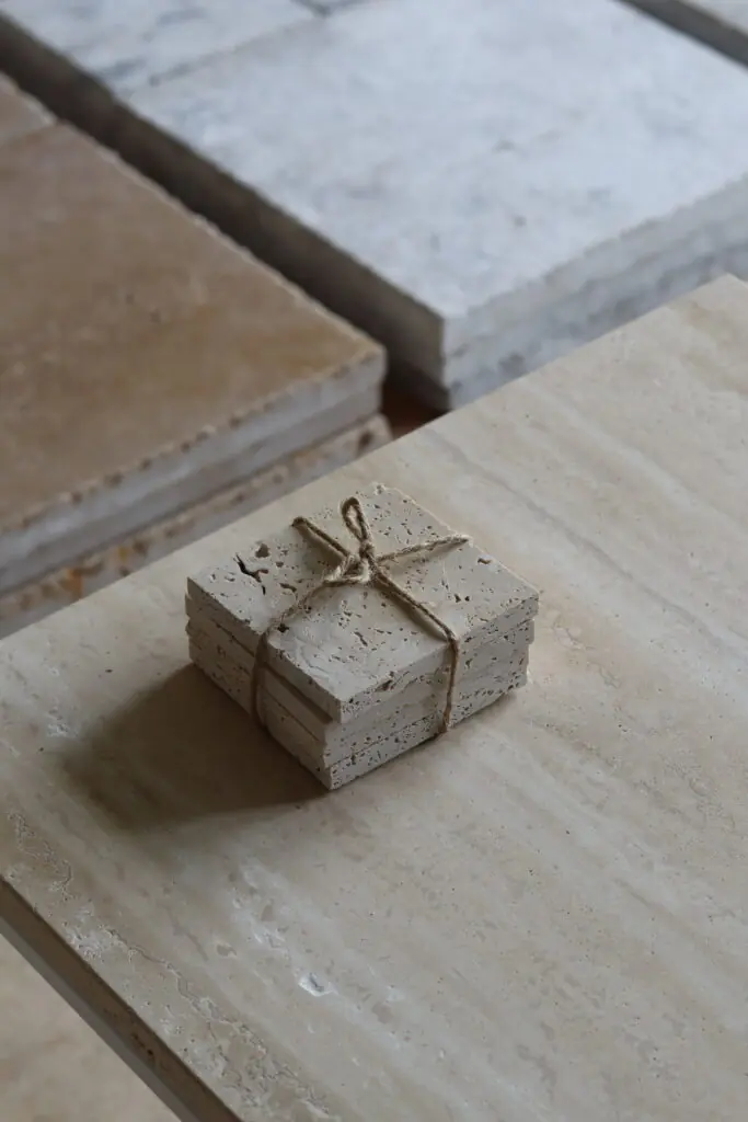 Próbki trawertyn Ivory Mix Szlifowany o wymiarach 10x10 cm, ułożone jedna na drugiej i związane sznurkiem.