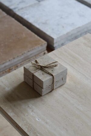 Próbki trawertyn Classic Mix 3cm Szlifowany o wymiarach 10x10 cm, ułożone jedna na drugiej i związane sznurkiem.