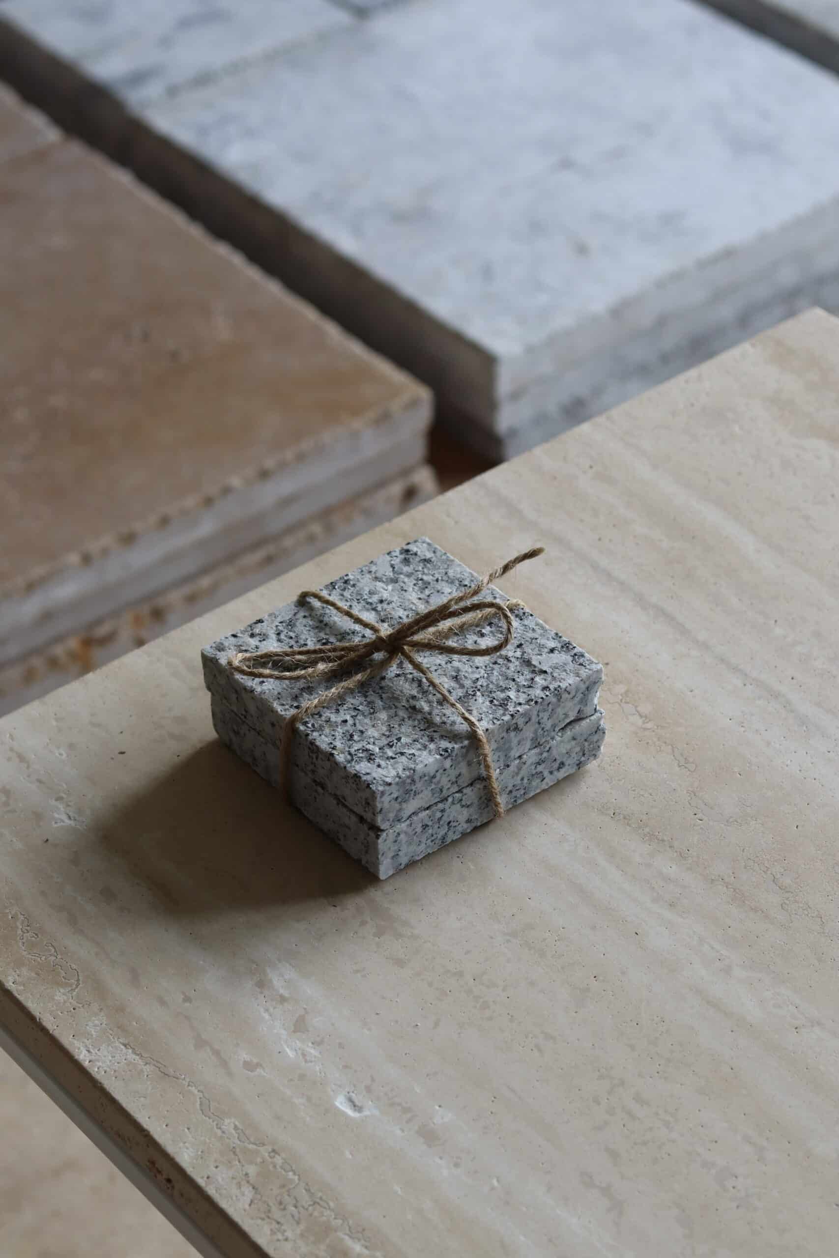 Próbki granit G602 Płomieniowany o wymiarach 10x10 cm, ułożone jedna na drugiej i związane sznurkiem.