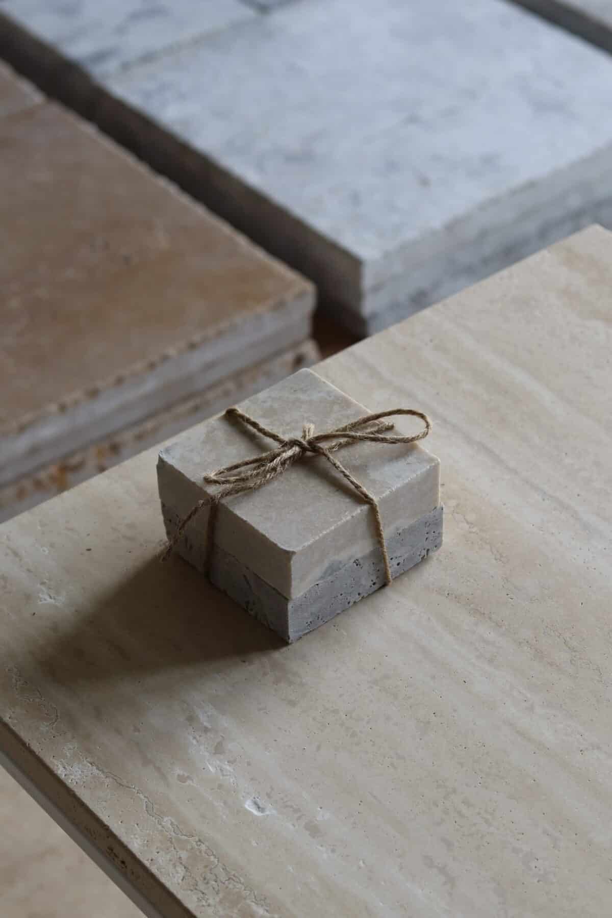 Próbki trawertyn Silver Latte 3cm Szlifowany o wymiarach 10x10 cm, ułożone jedna na drugiej i związane sznurkiem.