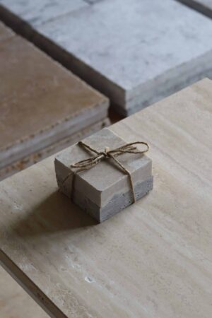 Próbki trawertyn Silver Latte 3cm Szlifowany o wymiarach 10x10 cm, ułożone jedna na drugiej i związane sznurkiem.