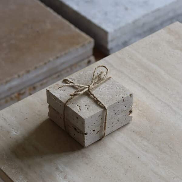 Próbki trawertyn Classic Light 3cm Szczotkowany o wymiarach 10x10 cm, ułożone jedna na drugiej i związane sznurkiem.