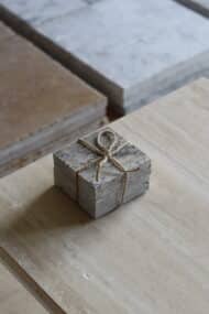 Próbki trawertyn Ash Mix 3cm Szlifowany o wymiarach 10x10 cm, ułożone jedna na drugiej i związane sznurkiem.