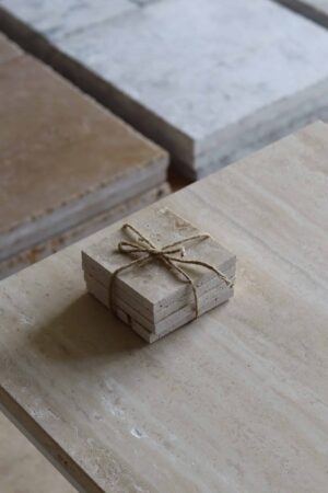 Próbki trawertyn Light Premium Szlifowany o wymiarach 10x10 cm, ułożone jedna na drugiej i związane sznurkiem.