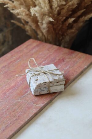 Próbki trawertyn Ivory Mix cegiełka o wymiarach 10x10 cm, ułożone jedna na drugiej i związane sznurkiem.
