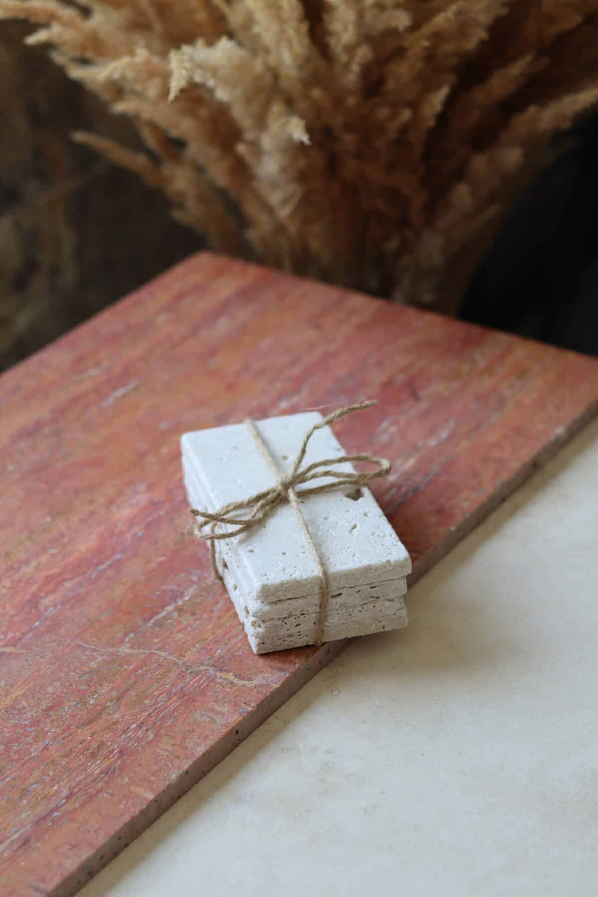 Próbki trawertyn Ivory Mix cegiełka o wymiarach 15x7,5 cm, ułożone jedna na drugiej i związane sznurkiem.