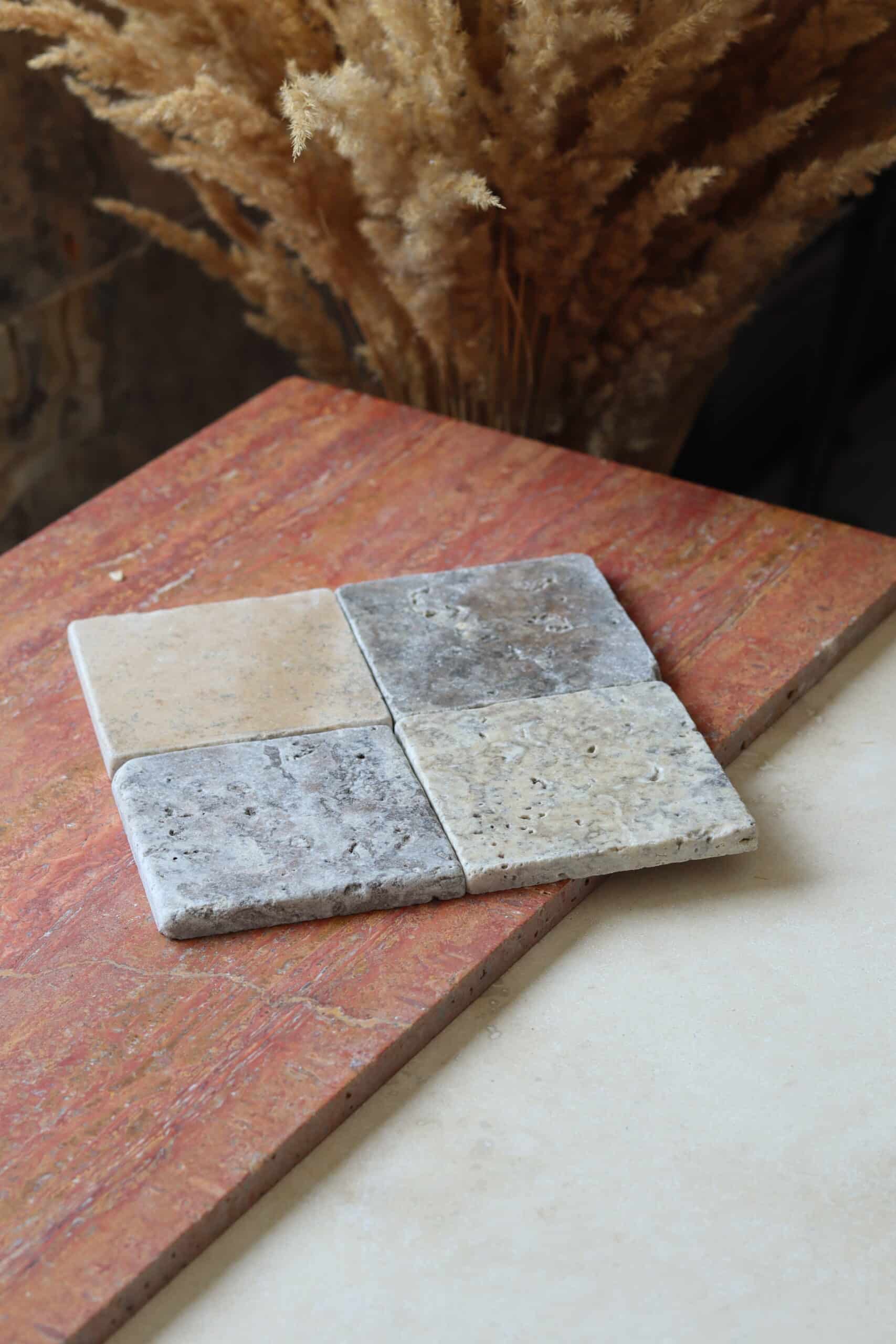 Próbki trawertyn Ash Mix cegiełka o wymiarach 10x10 cm, rozłożone obok siebie w jednym rzędzie.