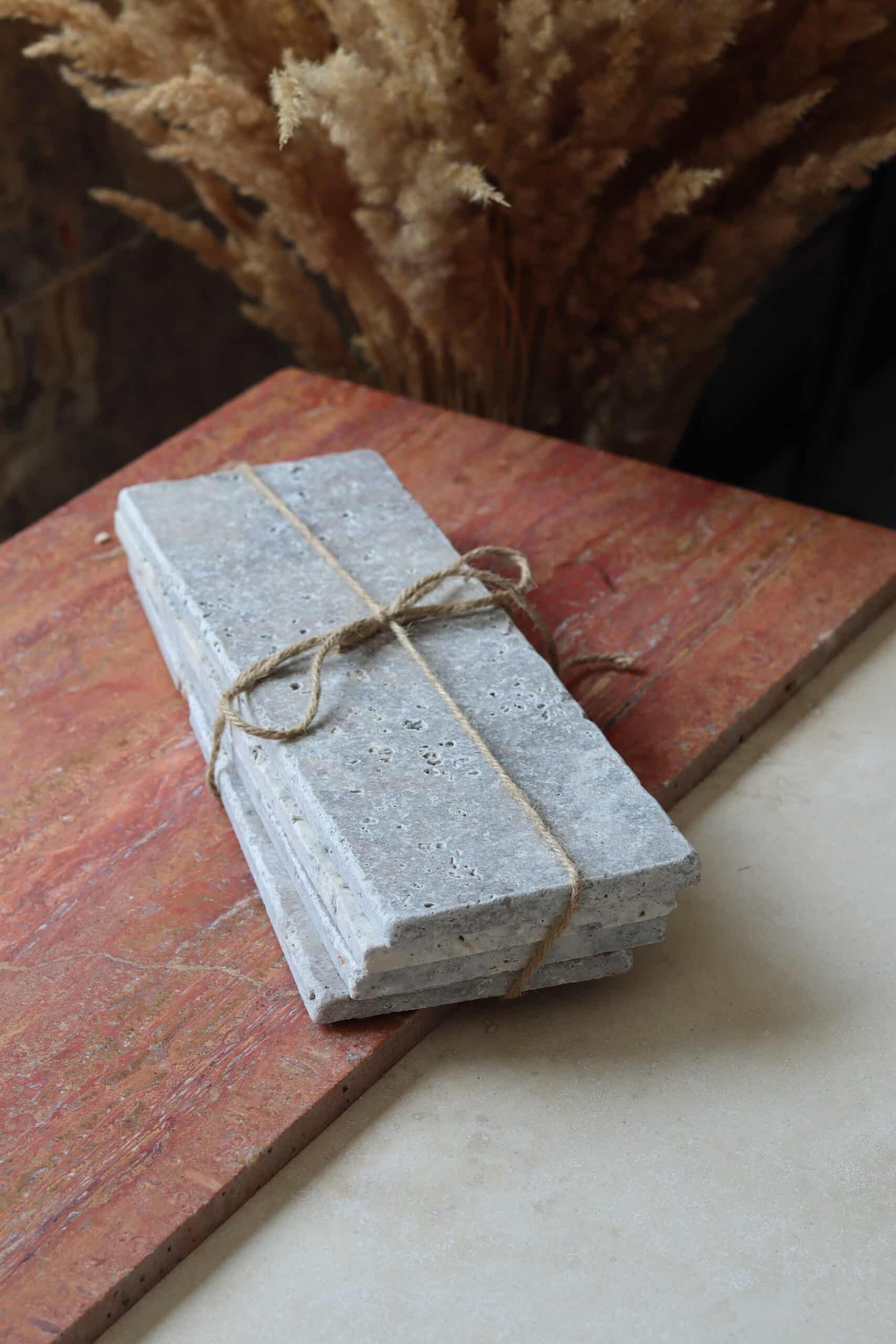 Próbki trawertyn Ash Mix cegiełka o wymiarach 30x10 cm, ułożone jedna na drugiej i związane sznurkiem.