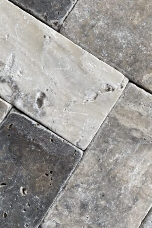 Zbliżenie na cegiełkę Trawertyn ASH 15x7,5x1 cm – bębnowane wykończenie, szary odcień.