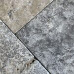 Zbliżenie na bębnowaną powierzchnię płytek ASH MIX – matowe wykończenie i odcienie szarości.