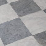 Płytki marmurowe BLUE antykowane ułożone w klasyczny wzór szachownicy, w odcieniach niebiesko-szarych, o subtelnie postarzonej powierzchni.