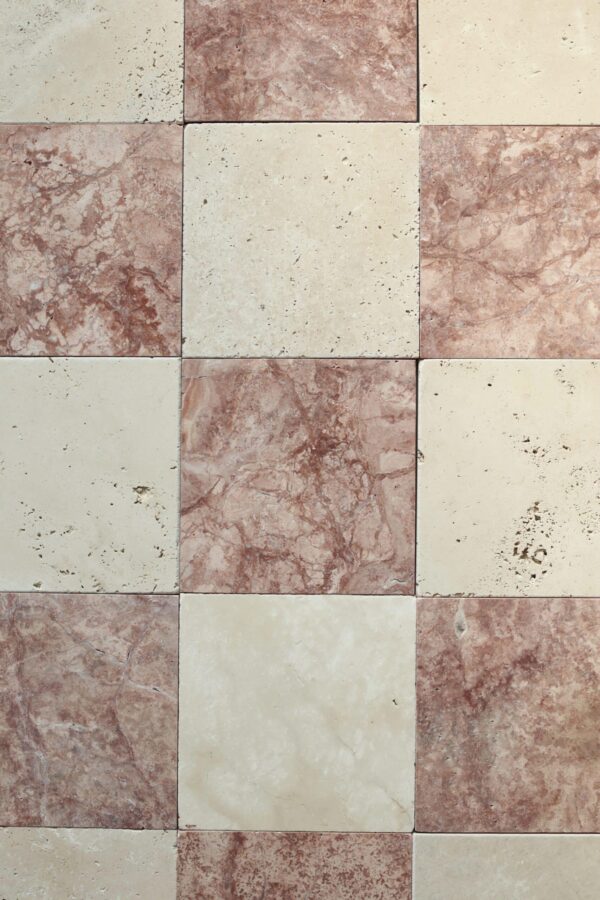 Szachownica z trawertynu w delikatnych odcieniach kremu i różu o subtelnej, szlifowanej powierzchni.