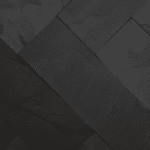 Zbliżenie na ścianę pokrytą czarnym łupkiem BLACK SLATE, ukazujące naturalną strukturę kamienia i jego elegancką, nieregularną fakturę.