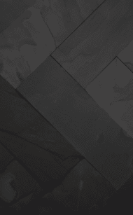Zbliżenie na ścianę pokrytą czarnym łupkiem BLACK SLATE, ukazujące naturalną strukturę kamienia i jego elegancką, nieregularną fakturę.