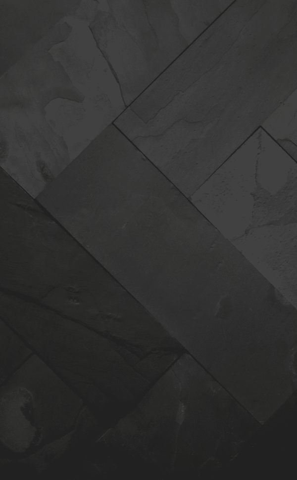 Zbliżenie na ścianę pokrytą czarnym łupkiem BLACK SLATE, ukazujące naturalną strukturę kamienia i jego elegancką, nieregularną fakturę.