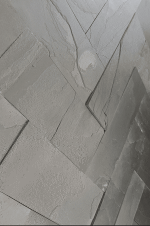 Nowoczesna ściana z czarnego łupka BLACK SLATE, prezentująca surową, nieregularną fakturę kamienia w efektownym świetle.