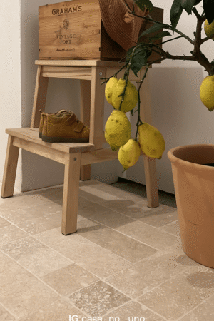 Płytka ceramiczna Ivory Mix 30x10 na podłodze, obok drewniany stołek z dziecięcymi butami i skrzynką Graham's, w towarzystwie doniczkowego drzewka cytrynowego.