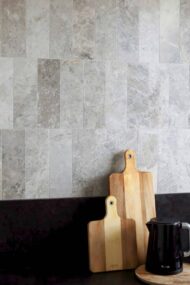 Kuchnia z marmurem Tundra Grey w stylu minimalistycznym, ciemnym blatem, czajnikiem i drewnianymi deskami.