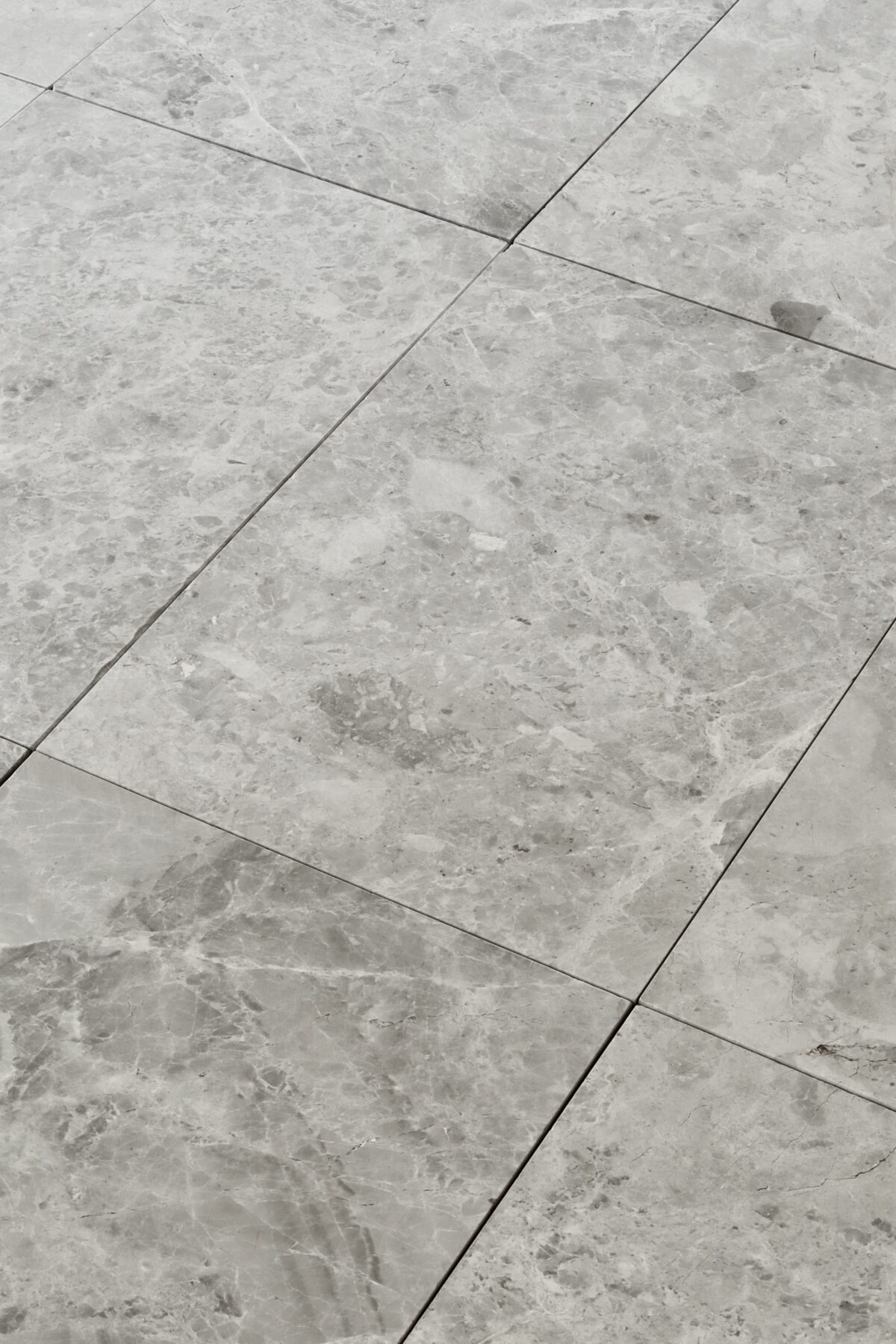 Zbliżenie na marmurowe płytki TUNDRA GREY w formacie 61x40,6 cm z szlifowanym wykończeniem i szarą tonacją