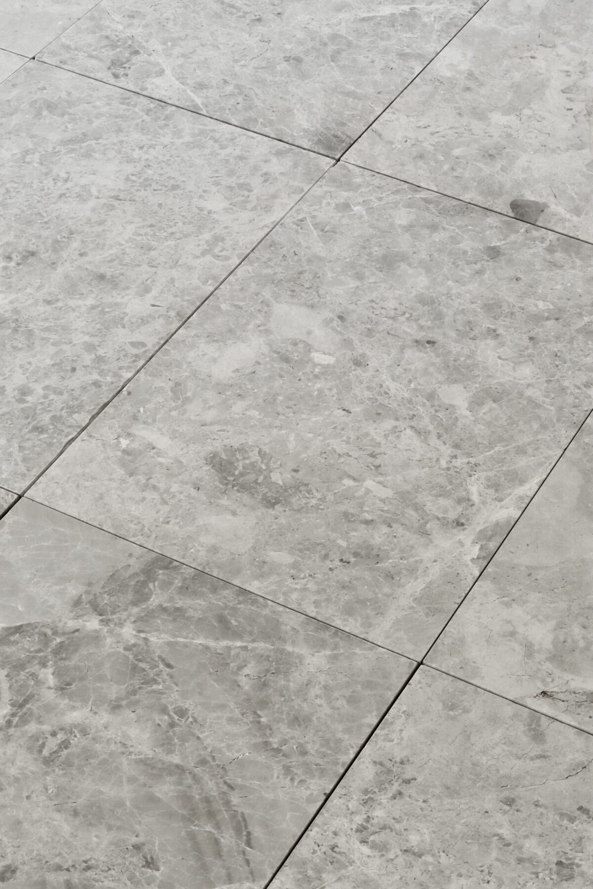 Zbliżenie na marmurowe płytki TUNDRA GREY w formacie 61x40,6 cm z szlifowanym wykończeniem i szarą tonacją