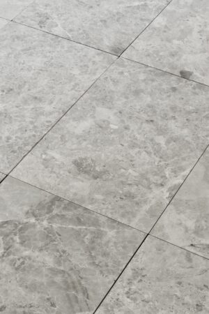 Zbliżenie na marmurowe płytki TUNDRA GREY w formacie 61x40,6 cm z szlifowanym wykończeniem i szarą tonacją