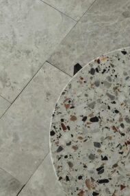 Podłoga z marmuru TUNDRA GREY w układzie rzymskim z widocznym stolikiem z lastryko