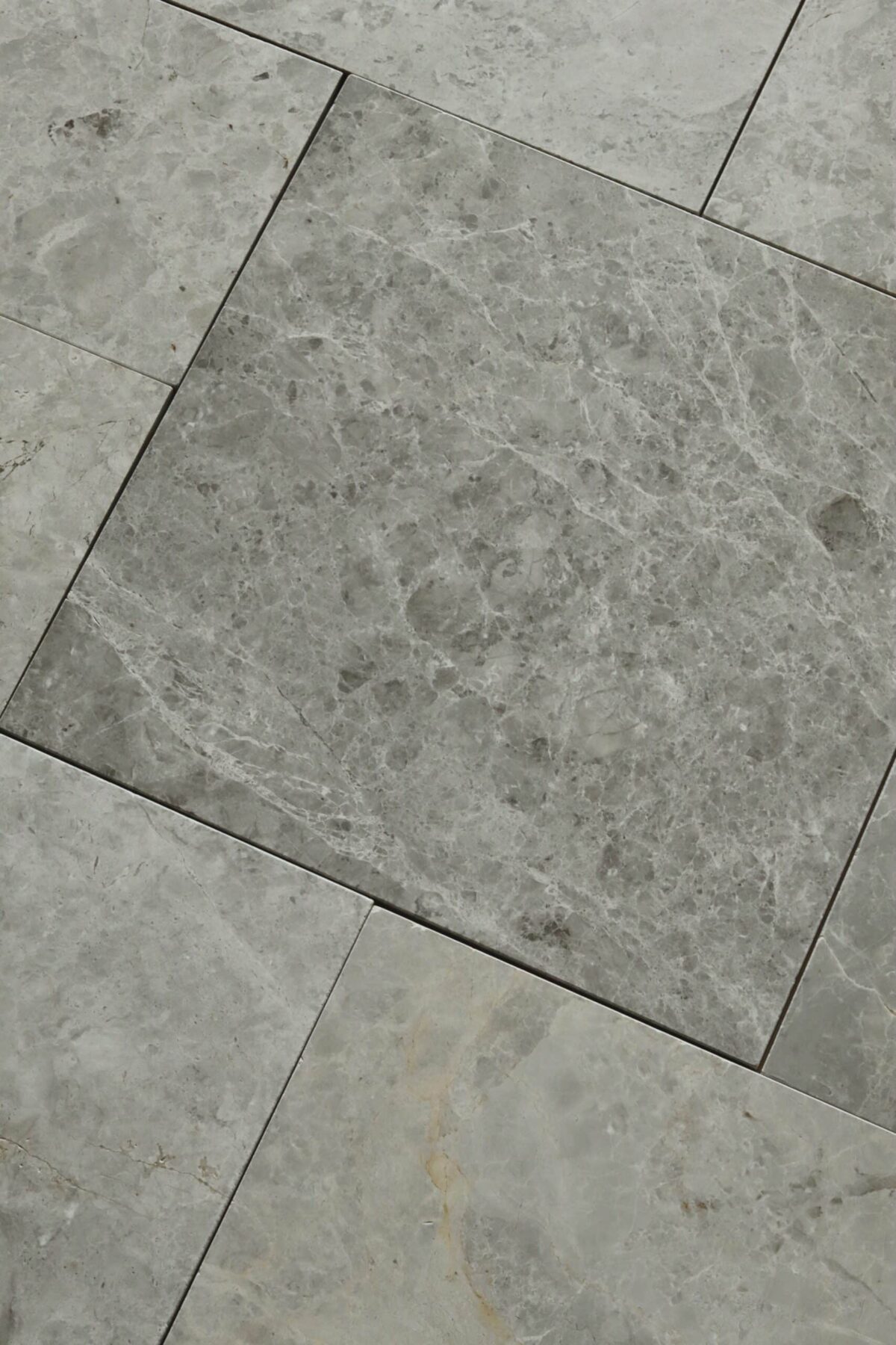 Zbliżenie na marmurowe płytki TUNDRA GREY w formacie rzymskim z widoczną strukturą kamienia