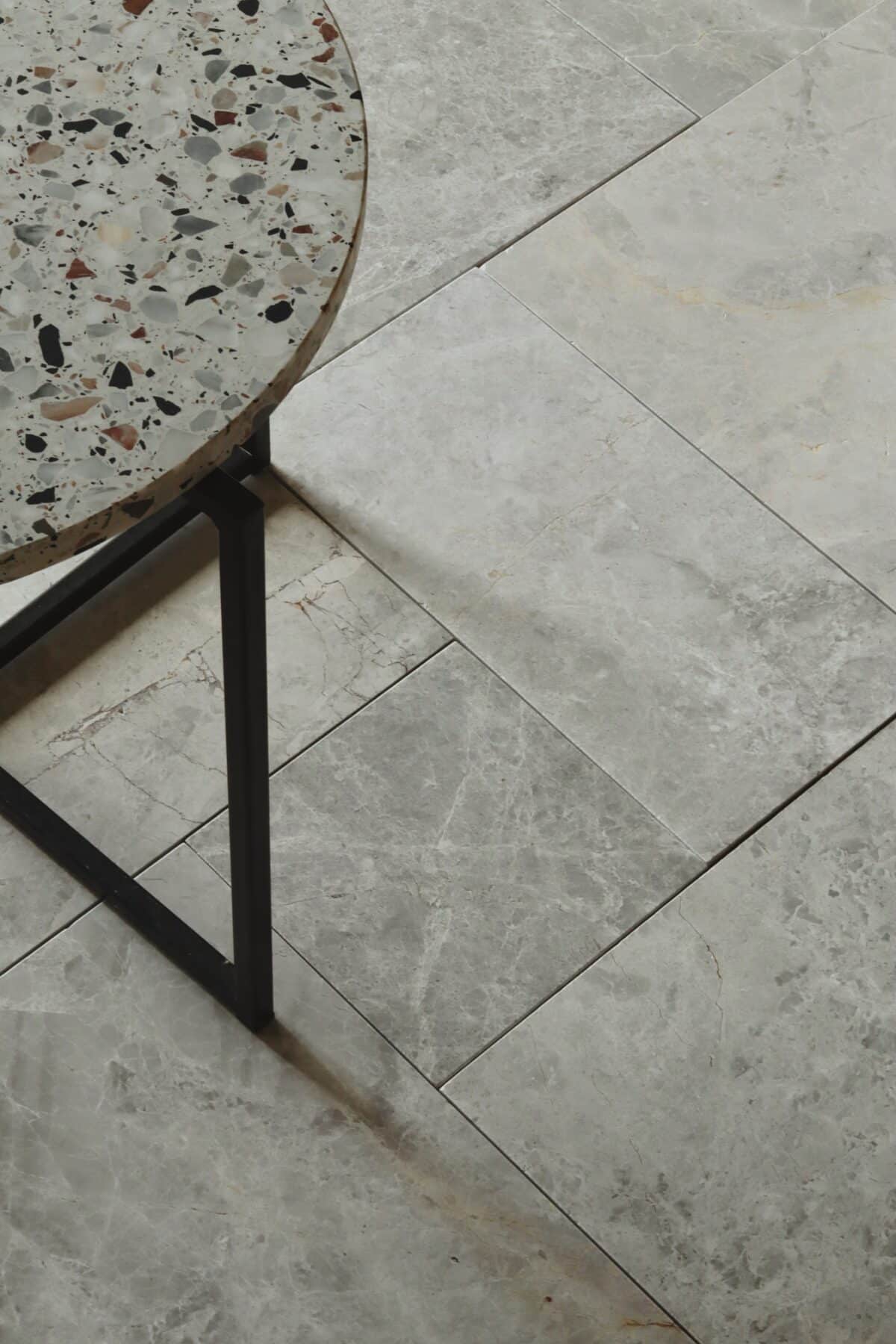 Płytki marmurowe TUNDRA GREY w formacie rzymskim z okrągłym blatem z lastryko w kadrze