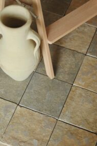 Płytki wapienne TANDUR YELLOW w aranżacji z jasnym dzbanem i drewnianą drabinką, widoczna struktura kamienia